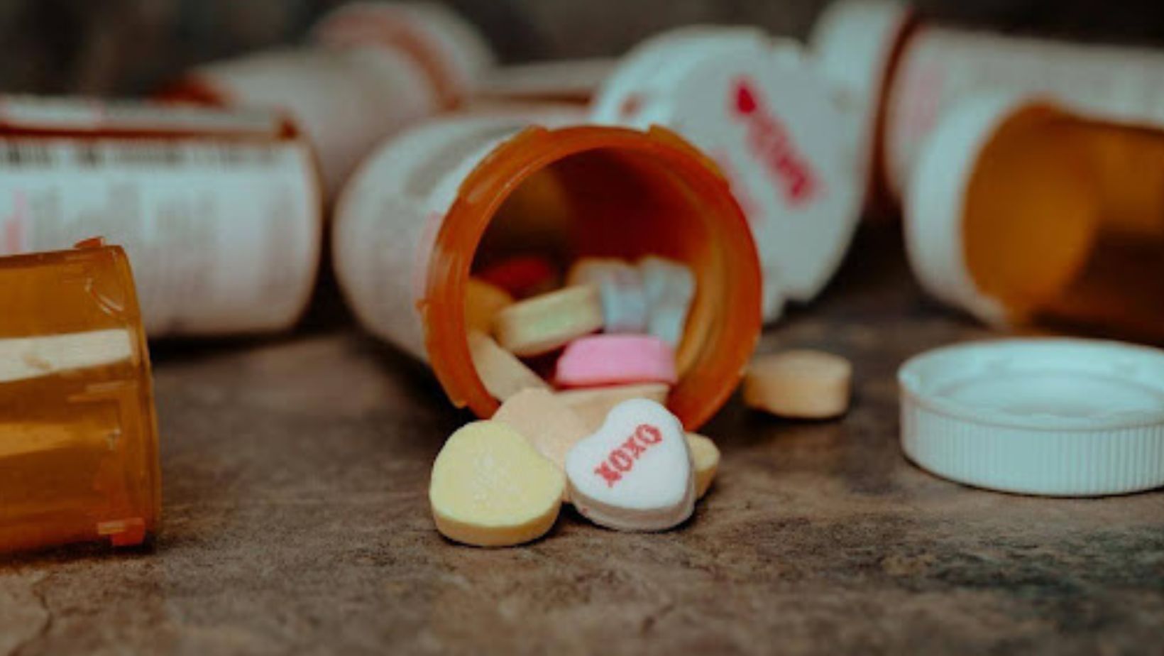 A couple of plastic bottles containing heart-shaped pills.
