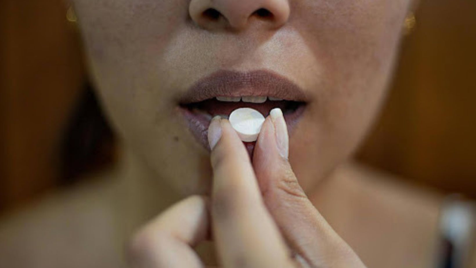 A person swallowing a pill.