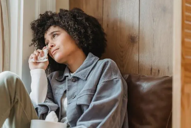 A woman wiping her tears with a tissue