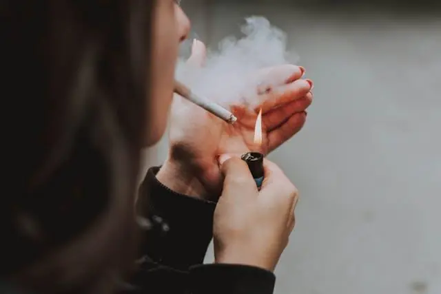 A woman lighting a cigarette
