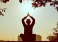 A silhouette of a person meditating outdoors at sunrise, symbolizing reflection and new beginnings.