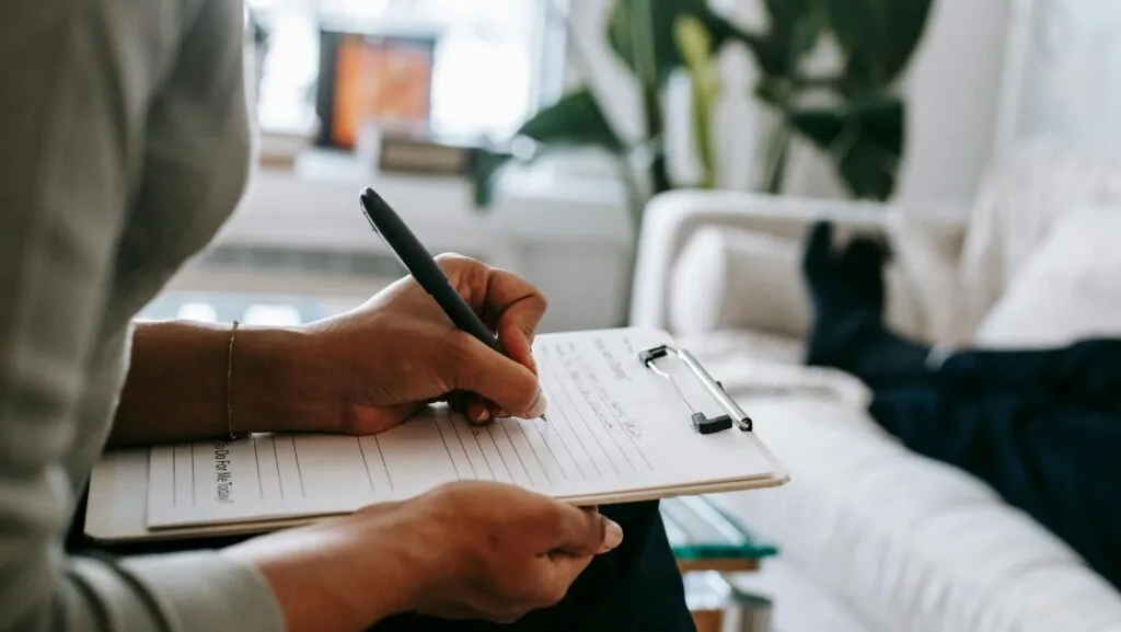 A therapist writing notes during a session