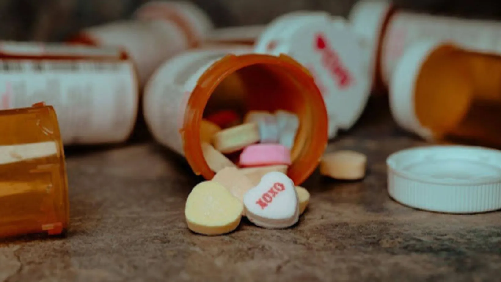 A couple of plastic bottles containing heart-shaped pills.
